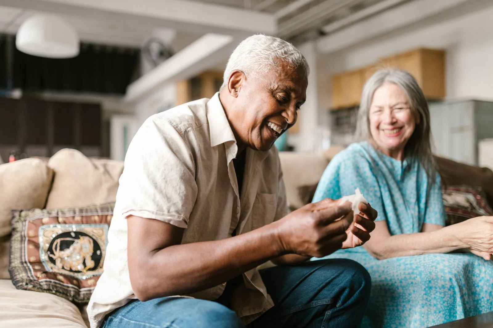 An older couple share an easy, happy moment at home.
